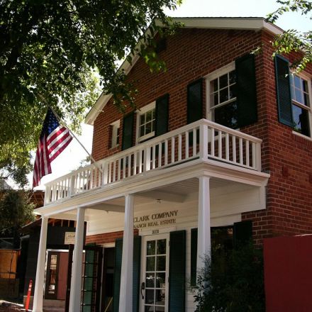 A brick building featuring an American flag prominently displayed on its front porch, symbolizing patriotism and community.